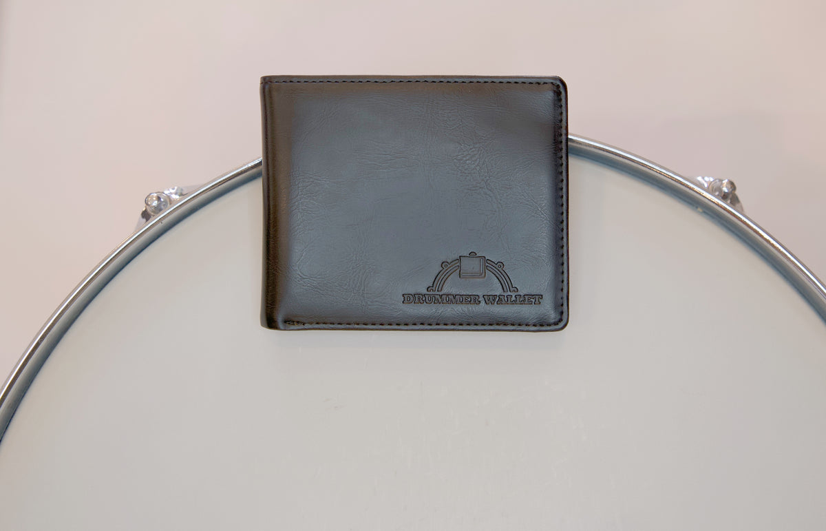 A black wallet with a magnetic strip, placed on a drum, designed specifically for drummers.
